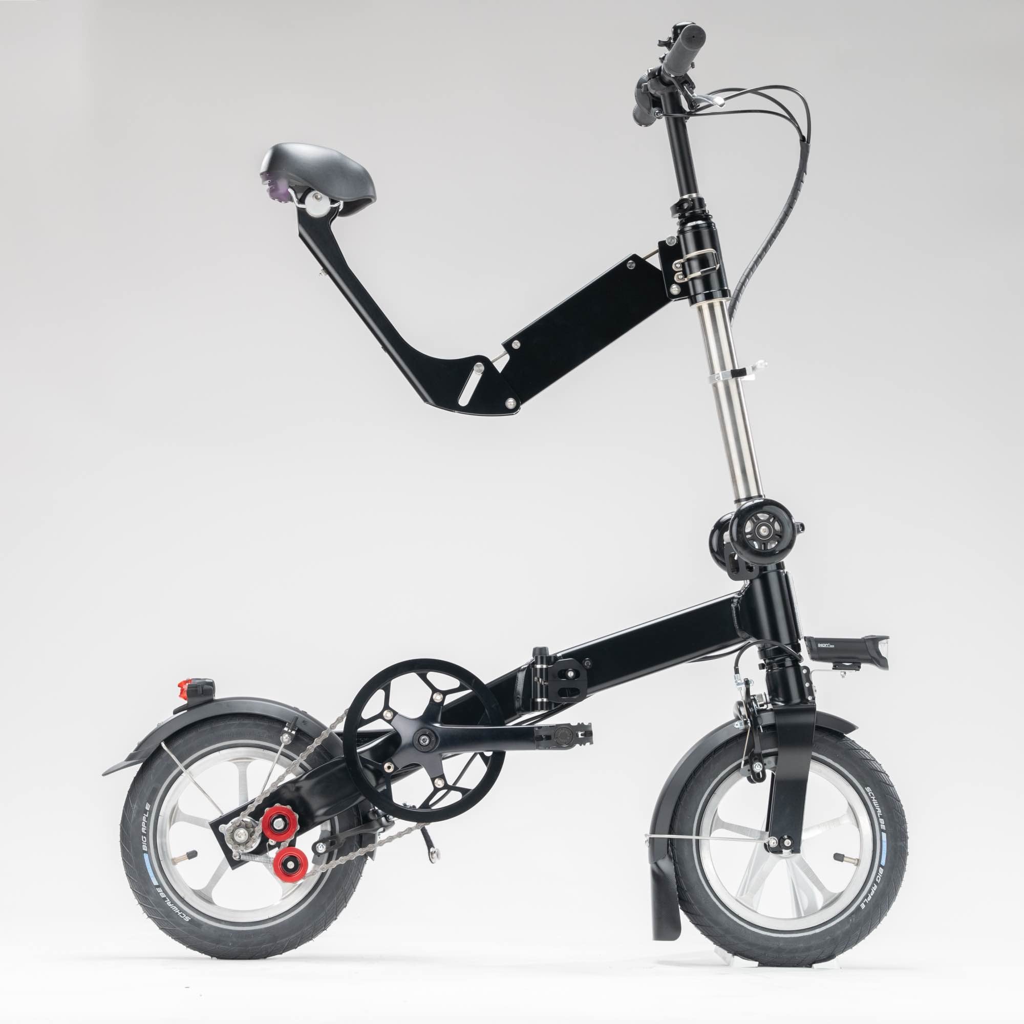 Black upride folding bike shown from the side, with mudguards, light, rack, and 3-speed transmission.