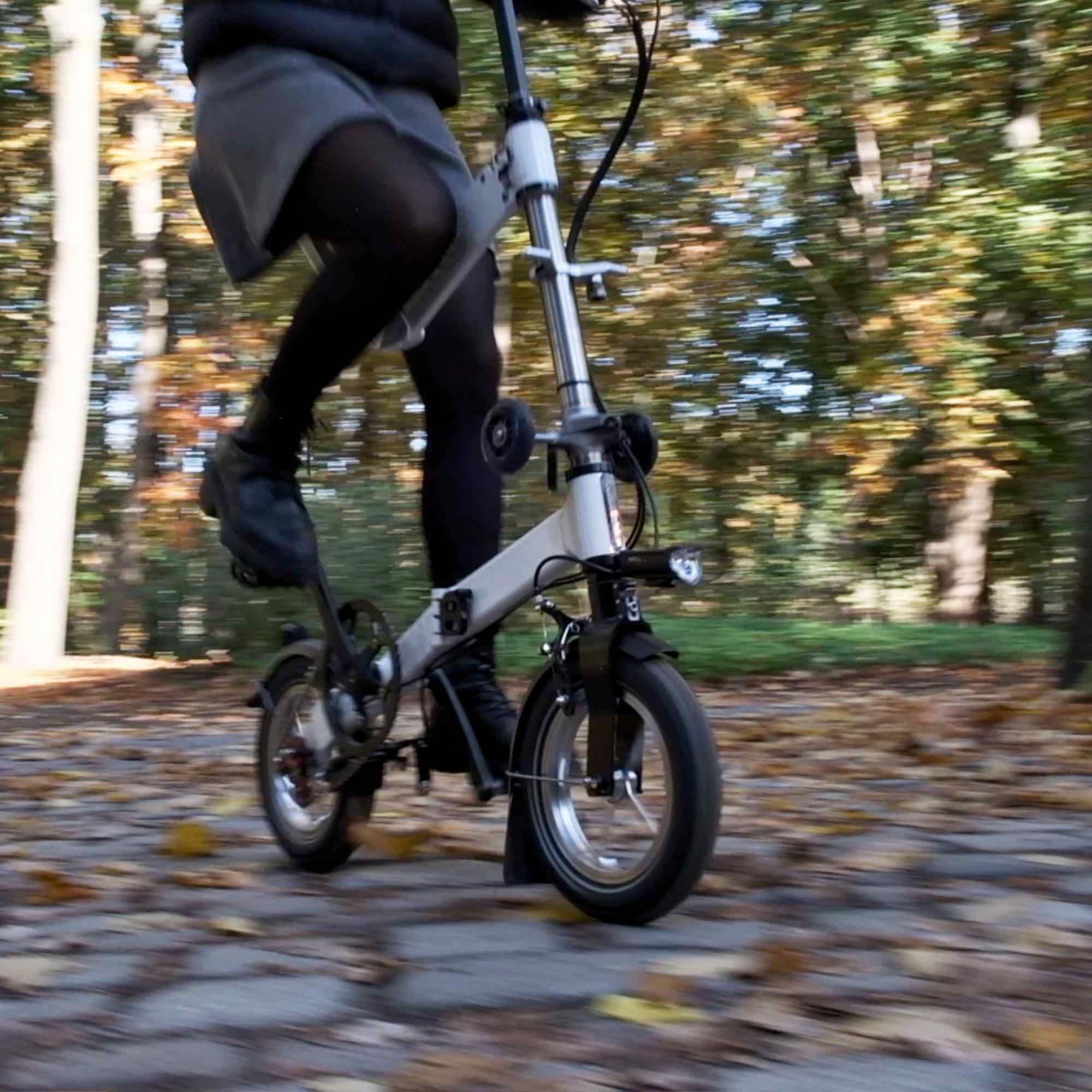 upride folding bike ridden over cobblestones. upright posture. full suspension. comfortable ride.