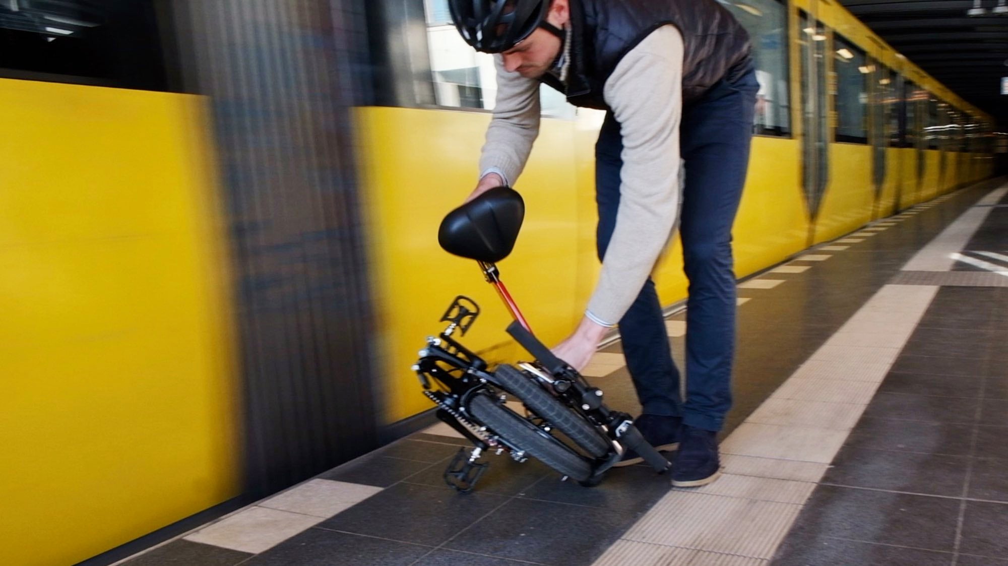 upride folding bike is being folded into hand luggage size